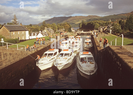 Una flottiglia di barche in volo di serrature su Caledonian Canal a Fort Augustus Loch Ness è in background Foto Stock