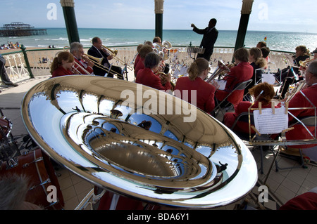 Un conduttore conduce la Patcham fascia argento in un concerto a Brighton bandstand con un ingrandimento di una tuba in primo piano. Foto Stock