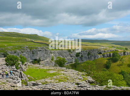 Le persone camminare sul marciapiede di calcare sulla cima di Malham Cove, Yorkshire Dales National Park, North Yorkshire, Inghilterra, Regno Unito Foto Stock