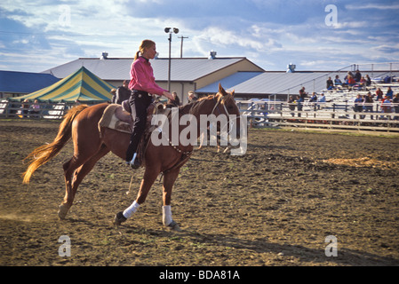 Giovane donna a cavallo nel giudicare l'arena di County Fair Foto Stock