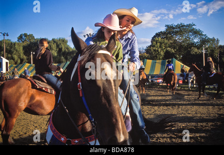I piloti di sesso femminile donna giovane ragazza a cavallo nel giudicare la zona della contea di rodeo Foto Stock