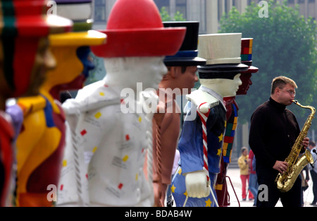Busker suonare il sassofono al fianco di Hans Hummel figure simboliche in Amburgo Germania Foto Stock