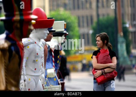 Una donna che guarda la Hans Hummel figure simboliche di Amburgo Germania Foto Stock