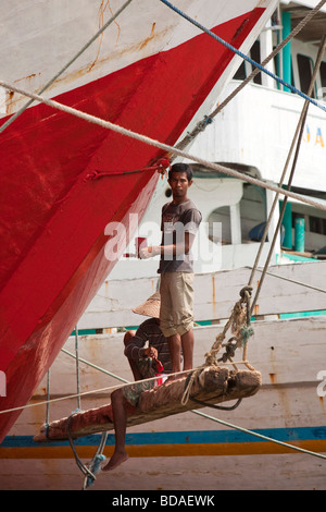 Indonesia Jakarta Java vecchia Batavia Sunda Kelapa uomini pittura tradizionale barca a vela in legno barca da carico Foto Stock