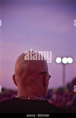 Testa calva man a County Fair guardando il rodeo. Foto Stock