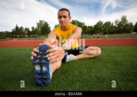Gli atleti il riscaldamento e lo stretching prima di fare qualche esercizio presso una locale scuola di alta via di Boulder, in Colorado. Foto Stock