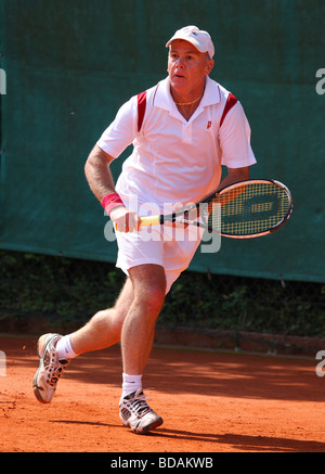 Uomo anziano Giocare il rovescio in un torneo di tennis Foto Stock