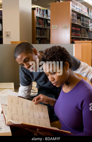 Giovane e attraente americano africano giovane studia in un armadio nella libreria Foto Stock