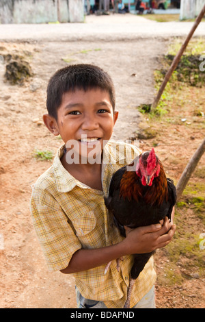 Indonesia Sulawesi operazione Labundo Wallacea Bundo bambino holding pollo domestico Foto Stock