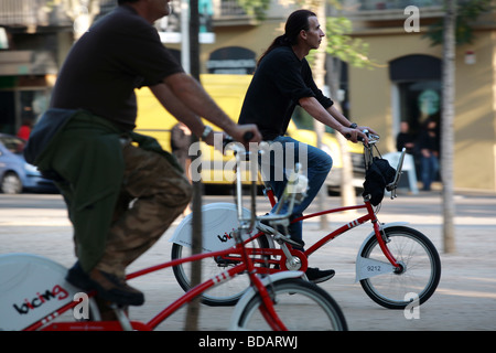 2 gente in bicicletta del programma Bicing nella città di Barcellona in Spagna Foto Stock