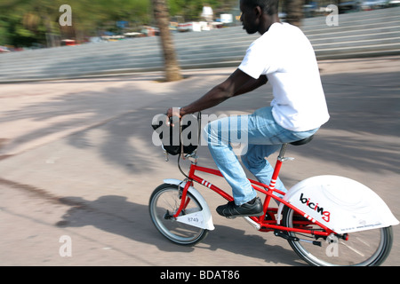 Un uomo in sella ad una bicicletta del programma Bicing nella città di Barcellona in Spagna Foto Stock