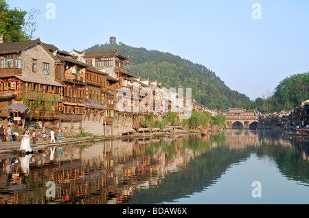 Il lungofiume di edifici di legno sul tuo fiume nella luce della sera la città antica di Fenghuang Hunan Cina Foto Stock