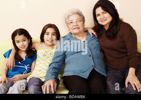 Ritratto di un senior donna seduta con la figlia e nipoti e sorridente Foto Stock