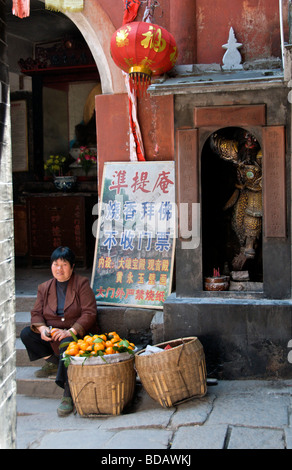 Donna vendita di arance in vicolo antica città di Fenghuang Hunan Cina Foto Stock
