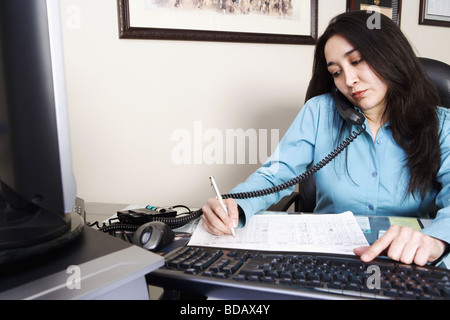 Imprenditrice parlando al telefono e lavora in un ufficio Foto Stock