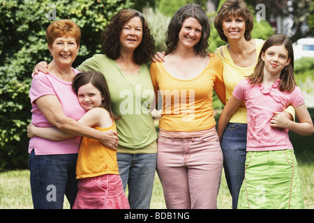 Due donne mature e senior donna in piedi in un parco con le loro figlie Foto Stock