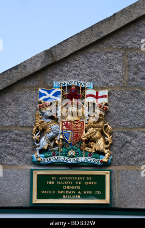 Targa a muro; Chemist Royal garantisce la nomina, Royal Coat of Arms, al Ballater Royal Deeside Cairngorms National Park, Scozia UK Foto Stock