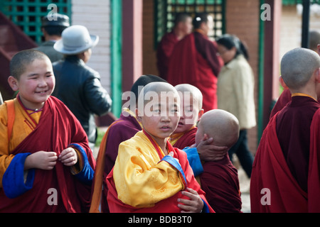 Mongolo giovani monaci buddisti giocare mentre si è in attesa per la cerimonia al monastero Gandan, ad Ulaan Baatar, Mongolia Foto Stock