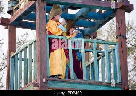 I giovani monaci buddisti soffiare il cerimoniale seashell corna in un tower presso il monastero Gandan, ad Ulaan Baatar, Mongolia Foto Stock