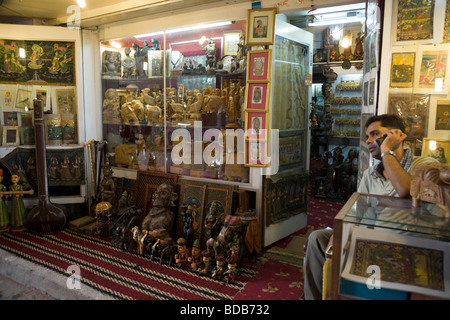 Negozio di articoli da regalo e souvenir e negoziante assistant parlando sul suo telefono cellulare. Chatta Chowk mercato, nella Red Fort. Delhi. India Foto Stock