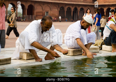 Maschio musulmano adoratori ceremonially lavare in acqua nella piscina della Jama Masjid (Grande Moschea). Delhi. India Foto Stock