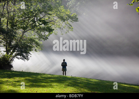 Pescatore a mosca con la nebbia mattutina e raggi di sole, sul fiume di Smith in Virginia, Stati Uniti d'America Foto Stock