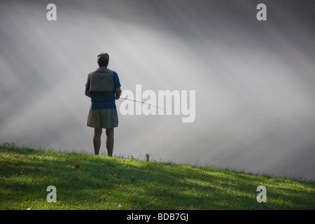 Pescatore a mosca con la nebbia mattutina e raggi di sole, sul fiume di Smith in Virginia, Stati Uniti d'America Foto Stock