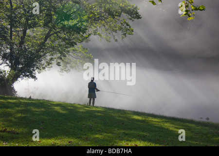 Pescatore a mosca con la nebbia mattutina e raggi di sole, sul fiume di Smith in Virginia, Stati Uniti d'America Foto Stock