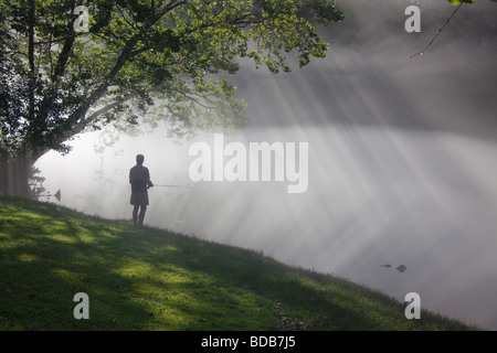 Pescatore a mosca con la nebbia mattutina e raggi di sole, sul fiume di Smith in Virginia, Stati Uniti d'America Foto Stock