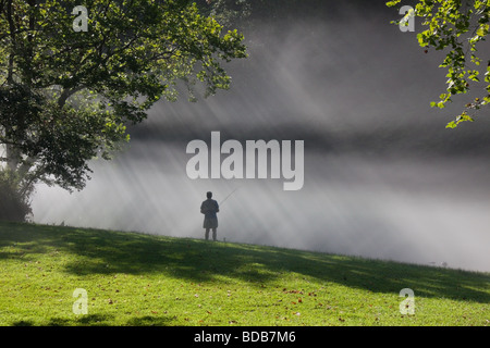 Pescatore a mosca con la nebbia mattutina e raggi di sole, sul fiume di Smith in Virginia, Stati Uniti d'America Foto Stock