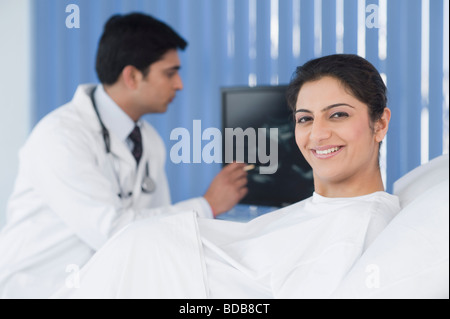 Ritratto di una donna incinta con un medico di sesso maschile in uno sfondo Foto Stock