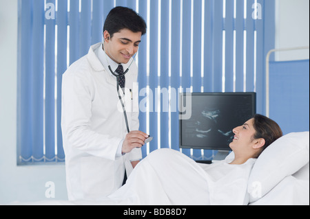 Medico esaminando una donna in stato di gravidanza Foto Stock