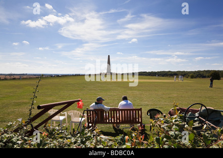 Spettatori guarda un villaggio partita di cricket in ombra del monumento Bilsington Bilsington Kent Foto Stock