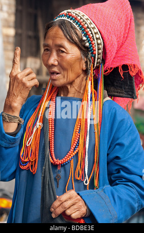 Akha donna tribale gesticolando al mercato Xiding, Yunnan, Cina Foto Stock