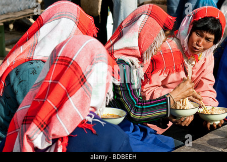 Hani donne tribali al mercato Xiding godendo di noodle soup per colazione, Yunnan, Cina Foto Stock
