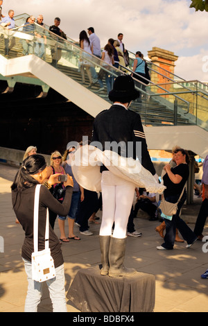 Tourist prende la foto del poliziotto artista di strada - South Bank di Londra, Inghilterra, Regno Unito, Europa Foto Stock