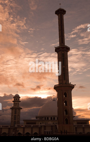 Indonesia Sulawesi Sengkang alto minareto della moschea principale di alta sopra la città skyline al tramonto Foto Stock
