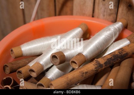 Indonesia Sulawesi Sengkang piccolo locale la tessitura della seta workshop bobine avvolte con filo bianco Foto Stock