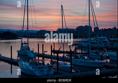 Barche e yacht inattive come il sole tramonta sul Porto Interno di Victoria, British Columbia, Canada. Foto Stock