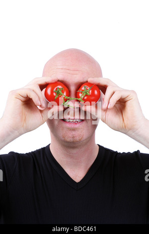 Testa calva uomo ha i pomodori di fronte ai suoi occhi Foto Stock