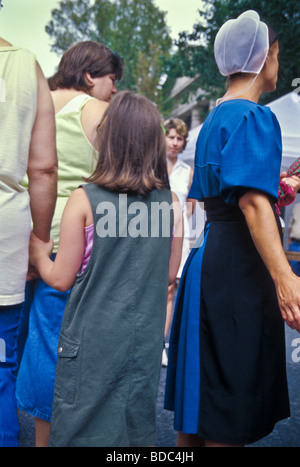 Giovane donna amish in vestito blu tra inglese al piccolo centro di arti e mestieri e fiera. Foto Stock