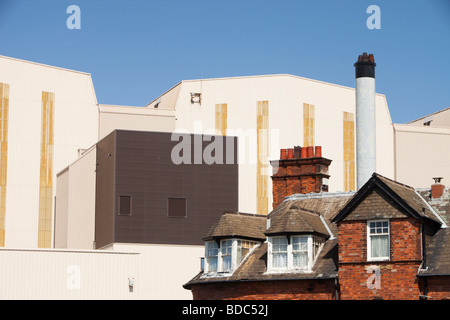 BAE Systems edifici adombrando vecchie case a schiera a Barrow in Furness, Cumbrias, UK. Foto Stock