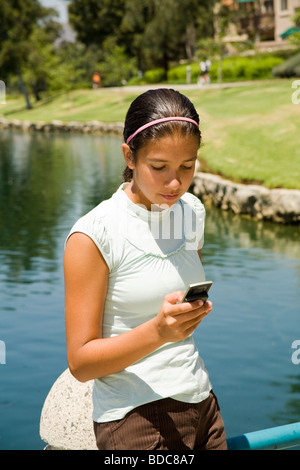 Tween tween Diverse multi ragazza ispanica sms sul cellulare. Signor Foto Stock