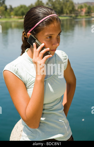 11-13 anni e anni giovane gente ragazza ispanica parlando al telefono cellulare. Tween tween giovane persone natura, naturale che circonda il signor © Myrleen Pearson Foto Stock