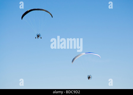 Un powered parapendii in volo contro un cielo blu chiaro Foto Stock