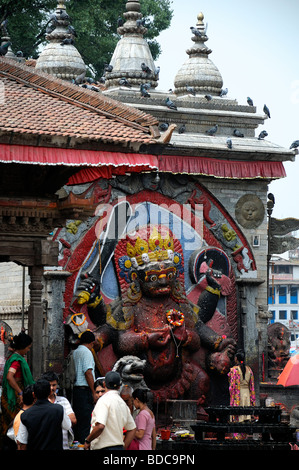 Nero Bhairab statua e fedeli pregano offerta rituale del culto Khal Bhairav Shiva il quadrato di Durbar Kathmandu in Nepal Foto Stock