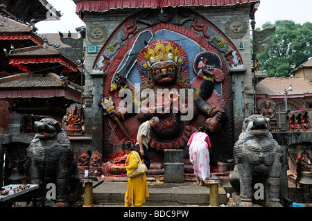 Nero Bhairab statua e fedeli pregano offerta rituale del culto Khal Bhairav Shiva il quadrato di Durbar Kathmandu in Nepal Foto Stock