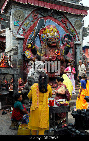 Nero Bhairab statua e fedeli pregano offerta rituale del culto Khal Bhairav Shiva il quadrato di Durbar Kathmandu in Nepal Foto Stock