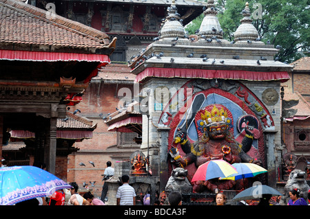 Nero Bhairab statua e fedeli pregano offerta rituale del culto Khal Bhairav Shiva il quadrato di Durbar Kathmandu in Nepal Foto Stock