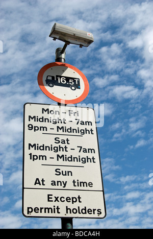 British cartello stradale che mostra le restrizioni per il parcheggio e il peso del veicolo limite, sotto cirrocumulous nuvole in East Sheen, a sud-ovest di Londra - Inghilterra Foto Stock